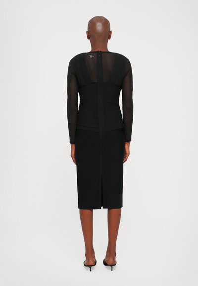 Μαύρο φόρεμα με εφαρμοστή σιλουέτα, διαφανείς μακριές μανίκες από δίχτυ, ρυζωμένο μπούστο και φερμουάρ στη μέση της πλάτης; μήκος έως το γόνατο με σκισίματα πίσω.