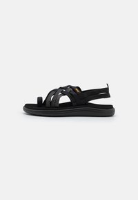 Svarta sandaler med vävd remdesign, tillverkade av syntetiska material. Platt sula och öppen baksida för lätt påtagning.