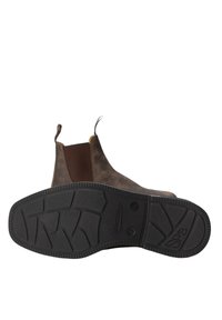 Brązowy skórzany botek za kostkę z elastycznymi panelami bocznymi, pętelkami do zakładania oraz teksturowaną gumową podeszwą z wyraźnym wzorem bieżnika.
