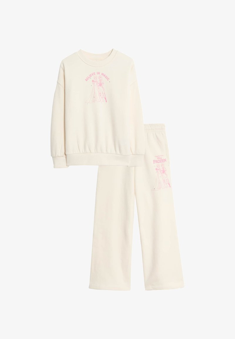 Crème kleurige sweatshirt en sweatpants set met roze grafische tekst "Geloof in Magie" en een personage uit Frozen op beide kledingstukken.