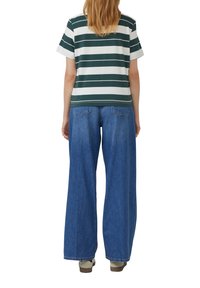 Gestreepte groen-witte katoenen t-shirt gecombineerd met wijde blauwe denim jeans, met een relaxte pasvorm en casual ontwerp.