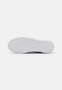 Semelle de sneaker blanche en caoutchouc texturé pour une meilleure adhérence, arborant un motif en forme de diamant et des bords lisses, conçue pour la durabilité et la traction.