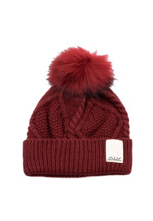 Cappellino lavorato a maglia di colore rosso scuro con motivo strutturato, ampia bordatura a coste e un soffice pompon sulla sommità. Include un piccolo etichetta bianca.