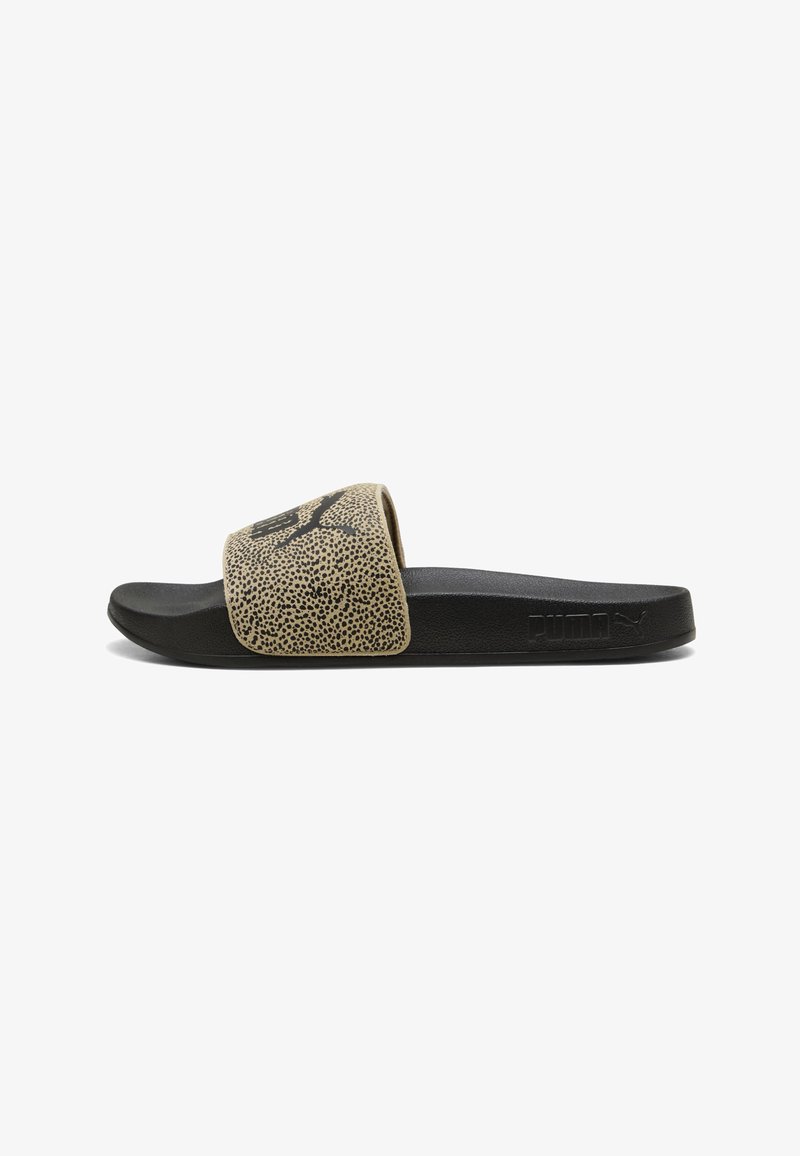 Sandale noire à glissière avec une sangle beige texturée présentant un logo Puma noir et un marquage Puma en relief sur le côté de la semelle.