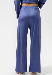 Wijde broek in een effen lichtpaarse stof, met een elastische tailleband. Glad textuur met een relaxte pasvorm, zonder zakken of zichtbare patronen.