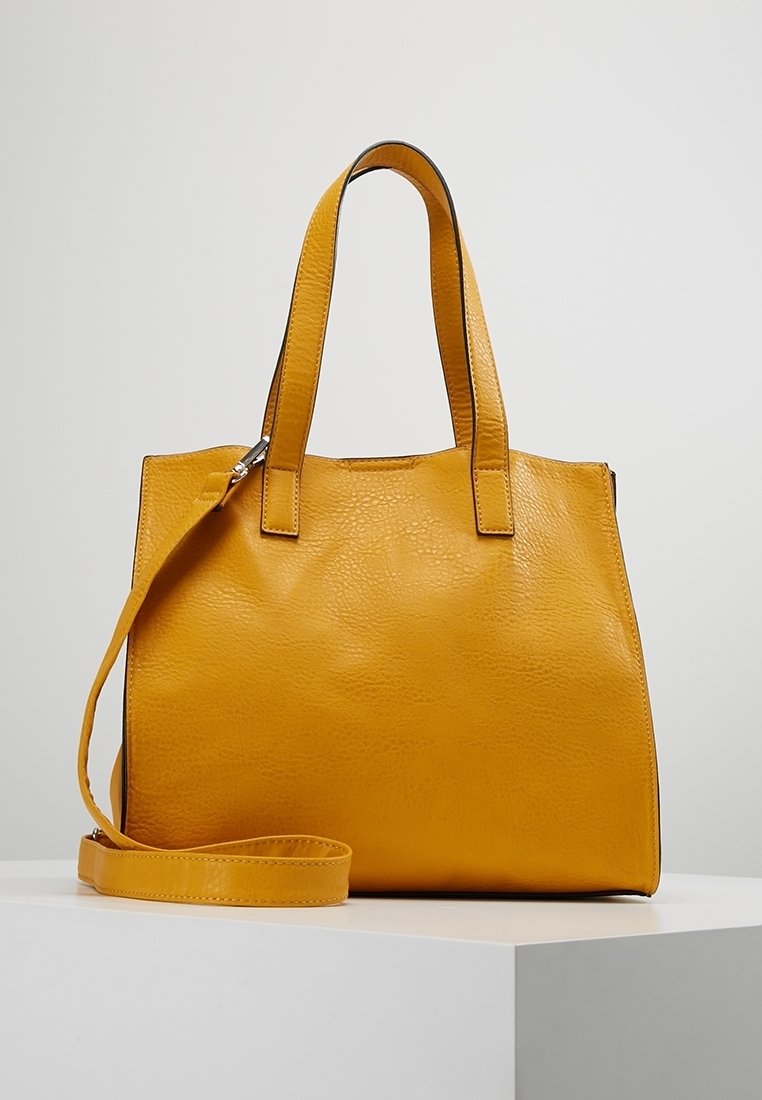 Gul læder tote taske med to top håndtag og en aftagelig skulderrem. Tekstureret overflade, rektangulær form og lynlås lukning.