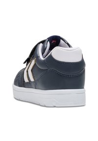 Marineblauwe leren sneaker met witte accenten, textuur op het oppervlak, gevoerde kraag en klittenbandsluiting. Dikke witte zool met profiel.