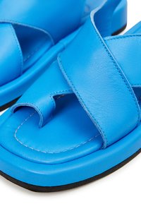 Sandali in pelle blu con design a fascia incrociata, punta rotonda, dettagli cuciti e suola in gomma nera per una migliore aderenza.