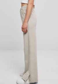 Lichtgrijze sweatpants met een elastische tailleband, zijzakken en een rechte pasvorm, met een subtiele textuur en een splitdetail aan de onderkant.
