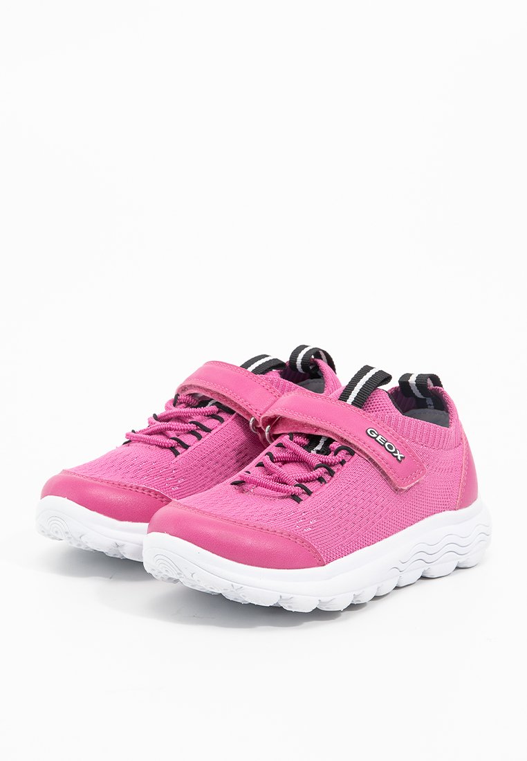 Scarpe per bambini rosa con tomaia in maglia, strap in velcro, dettagli neri e suola in gomma bianca con motivo a onda.