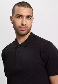 Czarna koszulka polo z teksturowanej tkaniny, krótkie rękawy, zapięcie na trzy guziki i subtelne logo na klatce piersiowej. Staranny kołnierz i dopasowany krój.