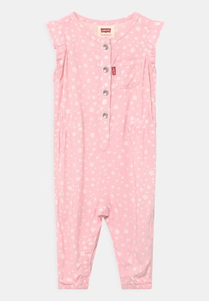 Barboteuse bébé rose sans manches avec imprimé floral blanc, boutons sur le devant, poche poitrine, et taille et ourlets des jambes élastiqués.