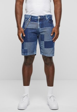 Denim shorts met een patchworkontwerp in verschillende tinten blauw, met een kettingdetail aan de riemlus en een rechte snit.