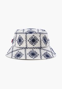 Cappello a secchiello bianco con ricami floreali blu navy e motivi a quadri, caratterizzato da una larga tesa e un tessuto texture.
