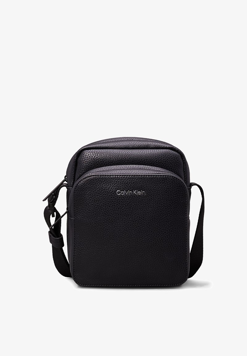 Borsa a tracolla in pelle nera con finitura testurizzata, caratterizzata da una tasca anteriore con zip e un semplice logo del brand sul davanti.