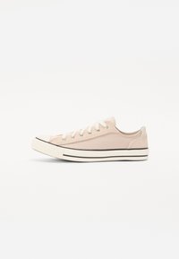 Heledad roosa kangastsneaker valge kummitamiga, musta triibuga ja metallist silmadega. Omab ümmargust varvaste osa ja traditsioonilist paelakinnitust.