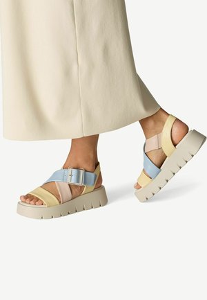 Sandales à plateforme colorées avec des brides jaunes, bleues et roses munies d'une large boucle. Semelle texturée avec des rainures profondes pour une meilleure adhérence.