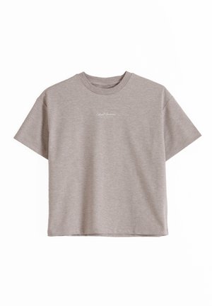 Camiseta de manga corta y cuello redondo de color gris claro con un pequeño texto blanco centrado cerca del cuello en la parte delantera.