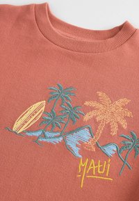Felpa corallo con superficie testurizzata, scollatura rotonda e vivace design ricamato di palme, montagne, tavola da surf e testo "MAUI".