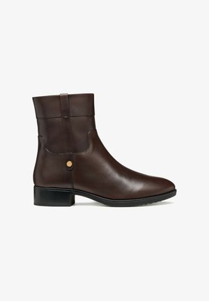 Bottine en cuir marron avec une finition lisse, bout légèrement arrondi, petit talon carré et sangle décorative avec un accent en métal.