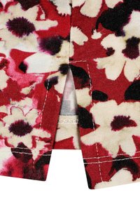 Stoff mit Floral-Design in Rot-, Creme- und Schwarztönen. Ausgestattet mit einem kleinen Schlitz und sichtbaren weißen Nähdetails.