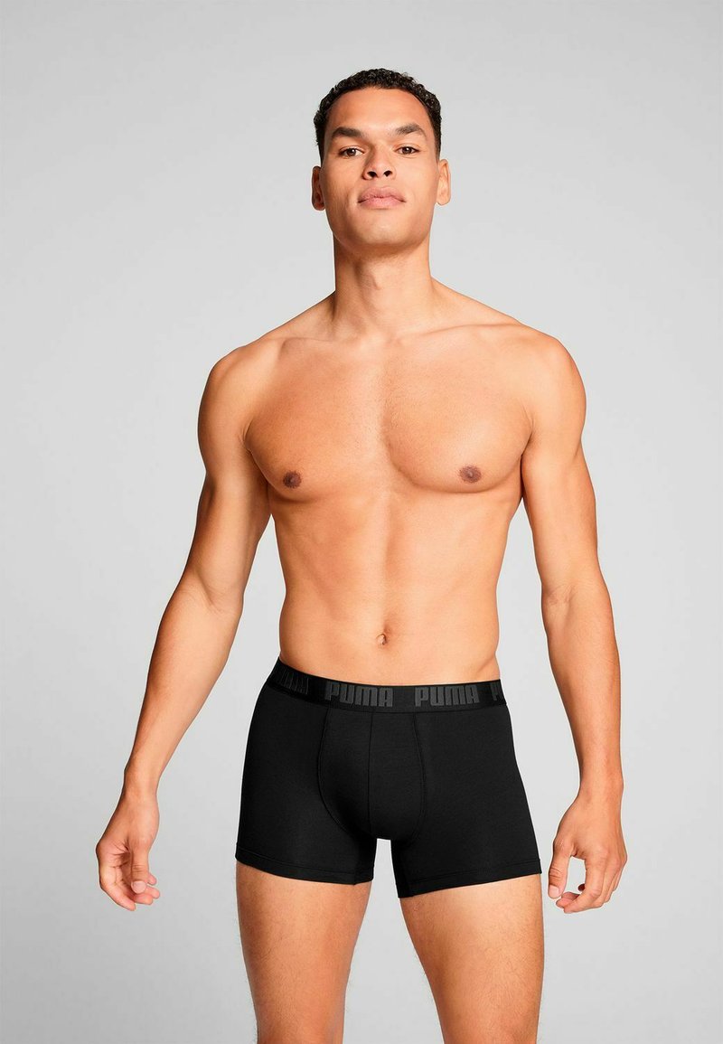 Black men's boxer briefs made of soft material with a branded elastic waistband. Features a snug fit and simple design.