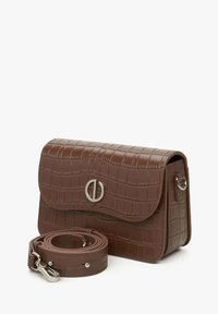Brązowa torba crossbody z ekoskóry o fakturze krokodyla, ze srebrnymi akcentami i odpinanym paskiem. Zapięcie na klapkę z okrągłym detalem.