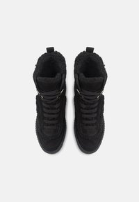 Černé semišové vysoké tenisky s měkkým interiérem, vybavené zlatými kovovými doplňky, silnými tkaničkami a strukturovanými detaily po stranách.