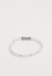 Pärlarmband med vita runda pärlor, insprängt med små silverdetaljer och ett texturerat silverfäste med magnet.