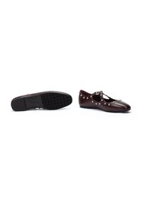 Zapatos planos burdeos con diseño recortado, adornados con tachuelas plateadas a lo largo de los bordes. Parte superior de cuero suave, suela de goma texturizada.