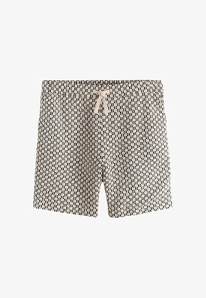 Lühikesed mustriga kangast lühikesed püksid musta-valge geomeetrilise mustriga ja heleroosa paelaga elastse vöökohaga.