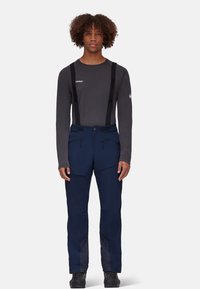 Granatowe wodoodporne spodnie z regulowanymi szelkami, wieloma kieszeniami i teksturowanymi akcentami. Połączone z szarym długim rękawem, minimalne logo.