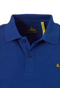 Blauwe poloshirt gemaakt van gestructureerde stof met een ribbelkraag, twee knopen en een klein geel logo nabij de rechteronderkant.