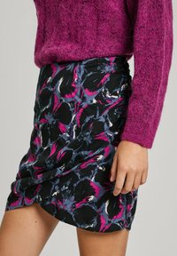 Schwarzer Minirock mit einem floralen Muster in Rosa, Marineblau und Weiß. Verfügt über eine figurbetonte Silhouette und geraffte Details an der Taille.