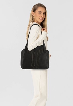 Borsa a tracolla nera in pelle con dettagli in borchie disposti in un motivo geometrico, dotata di due manici robusti e una forma strutturata.