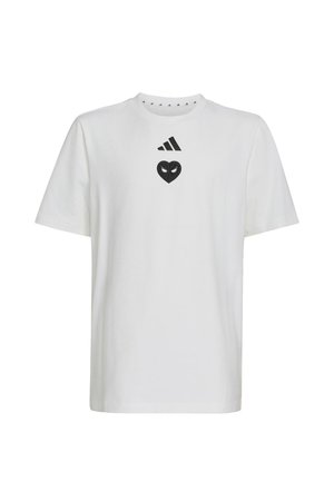 Biała koszulka z krótkim rękawem i okrągłym dekoltem, z czarnym logo Adidas oraz czarnym emblematem w kształcie serca z oczami na piersi.