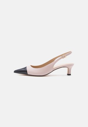 Two-tone beige and black slingback kitten heel shoe with pointed toe and small gold buckle on white background.