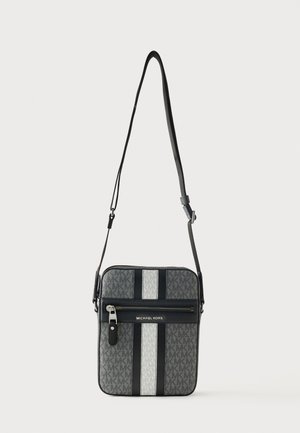 Sac bandoulière gris Michael Kors avec rayures verticales noires et blanches, poche avant zippée et bandoulière réglable.