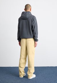Nike Sportswear CLUB PANT - Tepláky - team gold