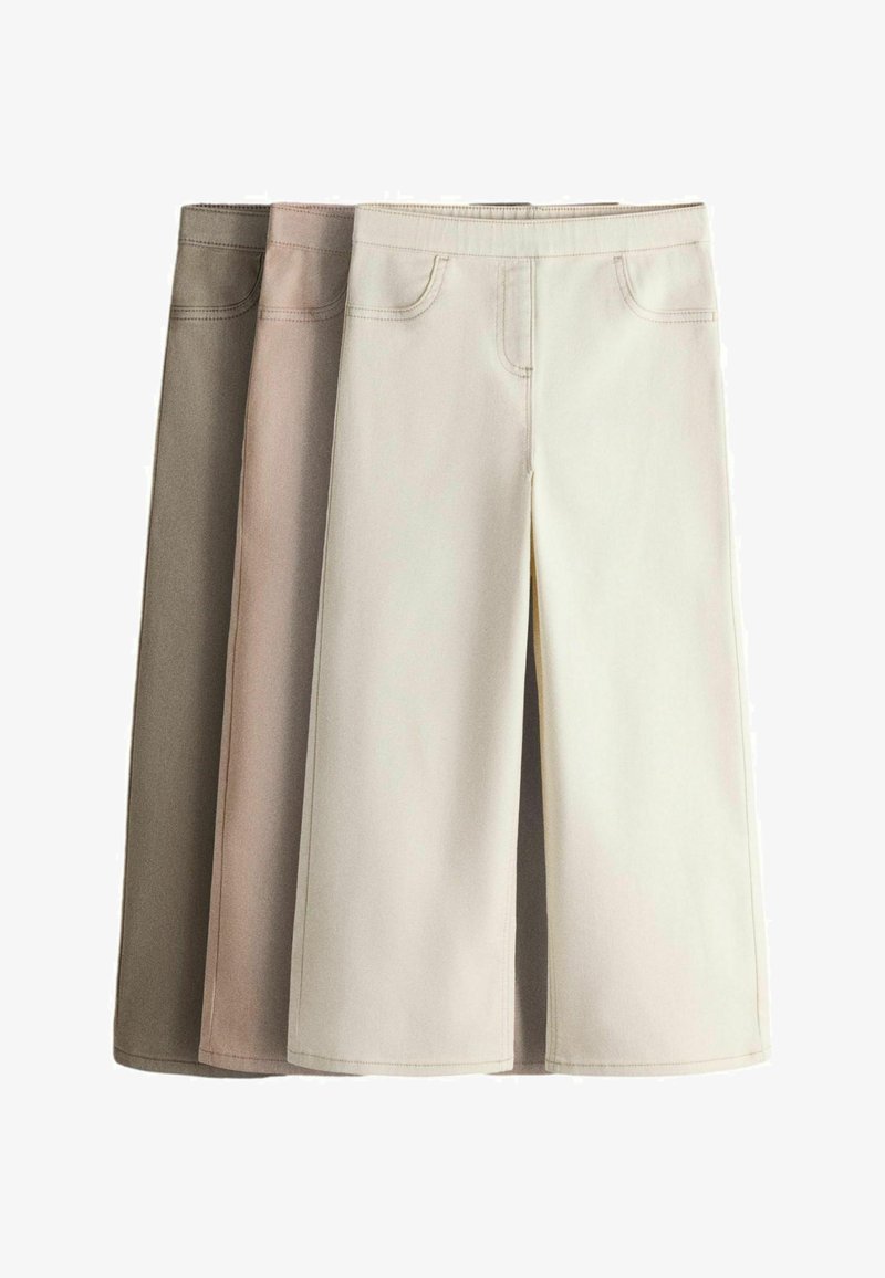 Tres faldas midi en beige, marrón claro y crema, con bolsillos delanteros y costuras visibles, colocadas planas y superpuestas.