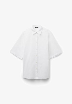 Biała koszula z krótkim rękawem zapinana na guziki, z ostrym kołnierzem, guzikami na przodzie i luźnym krojem, przedstawiona na białym tle.