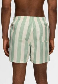 Gestreifte Badeshorts in Hellgrün und Creme, mit elastischem Bund, Seitentasche und weichem, glattem Stoff.