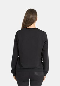 Schwarzer Baumwollpullover mit langen Ärmeln, Rundhalsausschnitt, gerippten Bündchen und Saum, mit glatter Textur und minimalistischem Design.