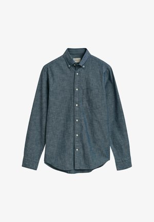 Donkerblauwe overhemd met knopen in een geweven stof, met een puntige kraag, lange mouwen en een linkervoorzak. Witte knopen zichtbaar.