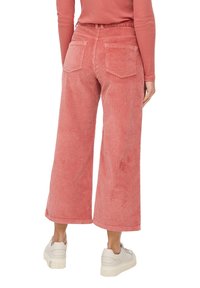 Pink corduroy wide-leg pants with a high waist, featuring two rear pockets and a textured, ribbed surface. Pairing with white sneakers.
