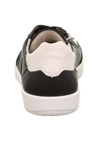 Schwarz-weiße Sneaker mit einem Obermaterial aus strukturiertem Leder, abgerundetem Absatz und einem Reißverschlussakzent auf der Rückseite. Minimalistisches Design mit weißer Sohle.