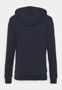 Sweat-shirt à capuche bleu marine avec une texture lisse, des manches longues et un ourlet côtelé aux poignets et à la taille. Présente un design simple.