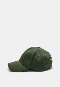 Cappellino da baseball verde in cotone con visiera curva, cinturino regolabile e logo ricamato sul lato. Texture liscia e design strutturato.