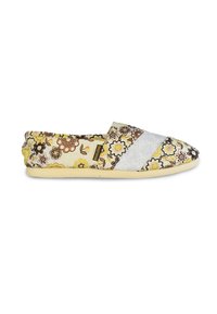 Zapato sin cordones con patrón floral que presenta una mezcla de tela amarilla, blanca y marrón. Punta redondeada, textura suave y suela flexible.