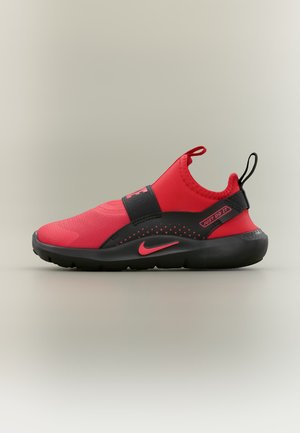 Chaussure de sport slip-on rouge et noire avec bride noire, virgule Nike rose et texte "Just Do It" sur fond neutre.